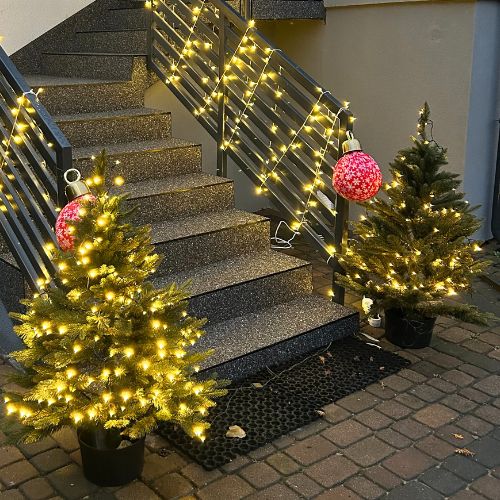 Sztuczna choinka w doniczce przed domem